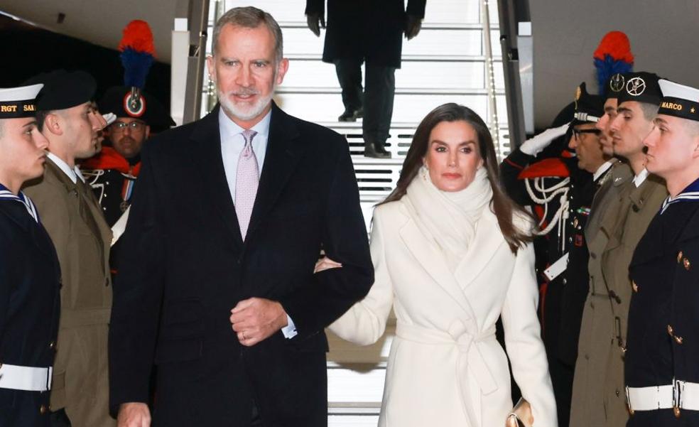 La reina Letizia sorprende en su llegada a Italia con un impoluto look blanco: abrigo largo y zapatos metalizados