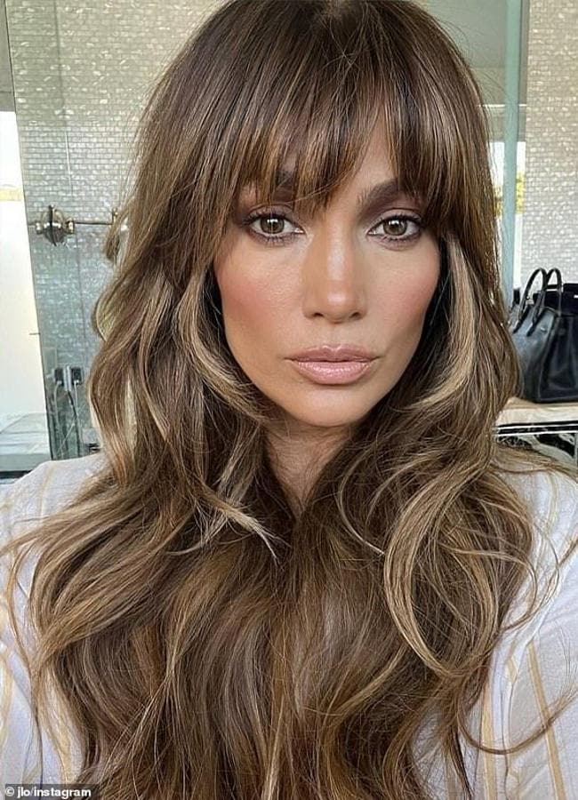 Jennifer Lopez con flequillo cortina en pelo largo ondulado/@jlo